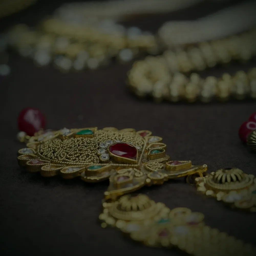 A 22 carat gold nakshi haram pendant set with rubies, emeralds and seed pearls.